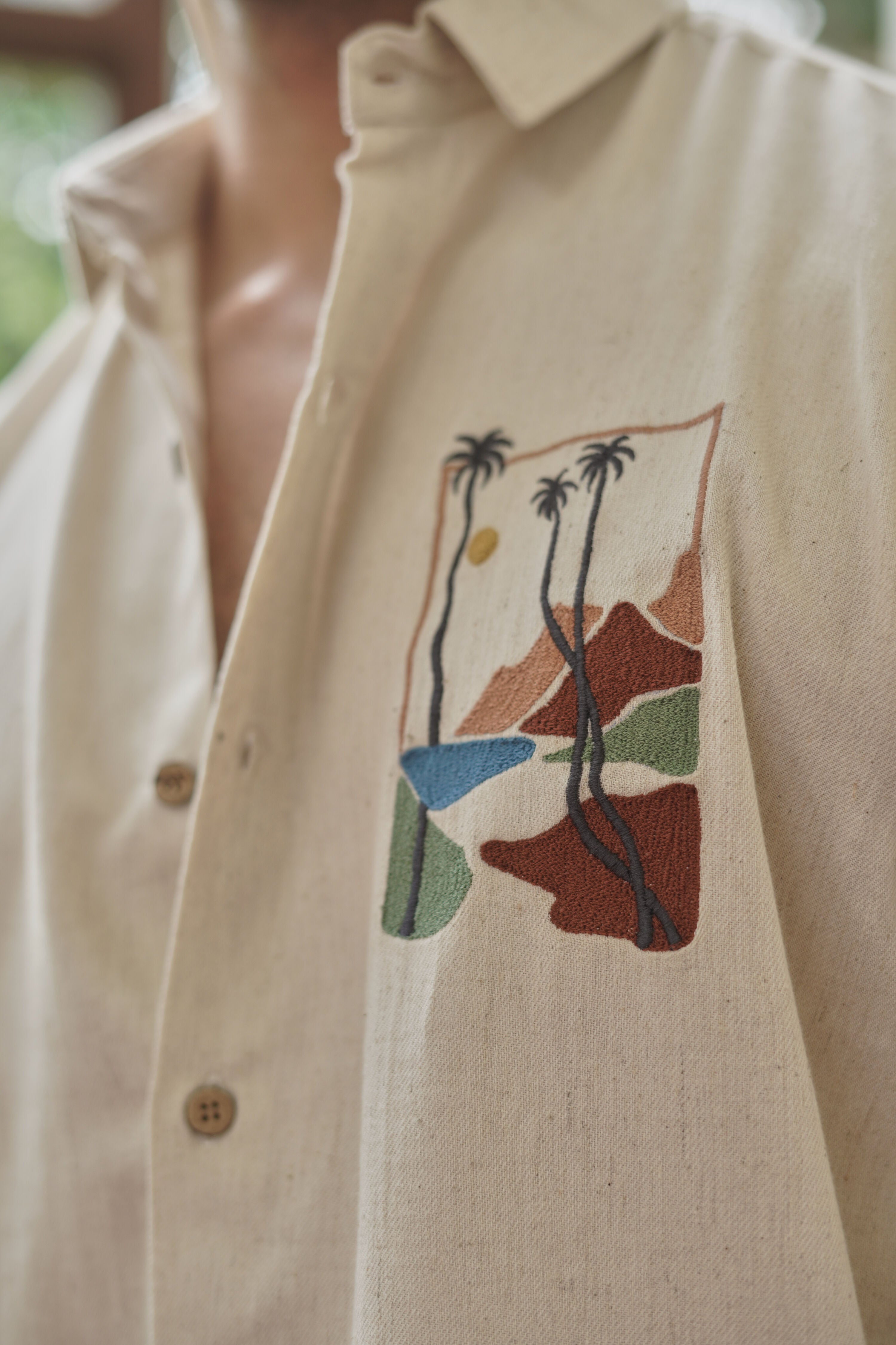 Beige embroidered shirt laid flat showing fabric texture and embroidery detail